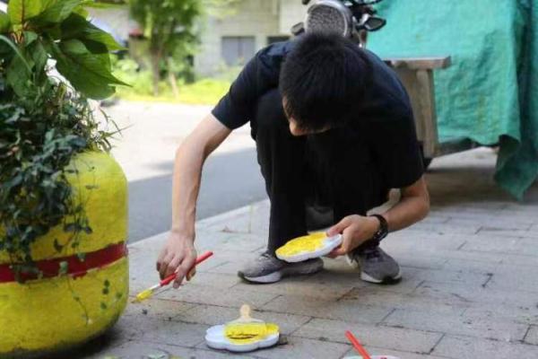 夜晚小区石墩险些绊倒老人：高中生用荧光颜料在上面作画提醒